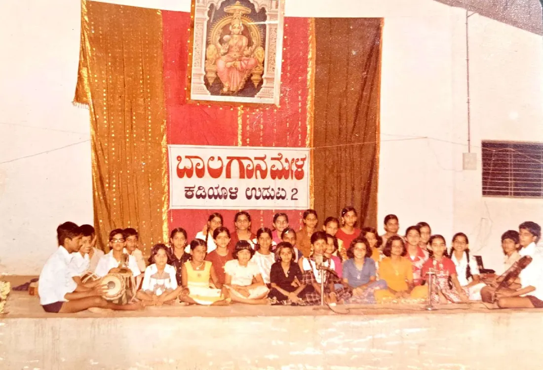 A large group of Bala Gana Mela students seated on stage with their accompanists